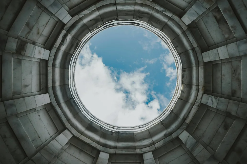 Low-angle view of a circular well open to the sky, a symbol of circularity
